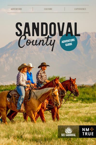 Cover art for Sandoval County Adventure Guide that shows a photo of three horseback riders wearing western hats in a green field in front of a mountain range.